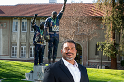 Black male in suit in front of Victory statue at 菠菜网lol正规平台